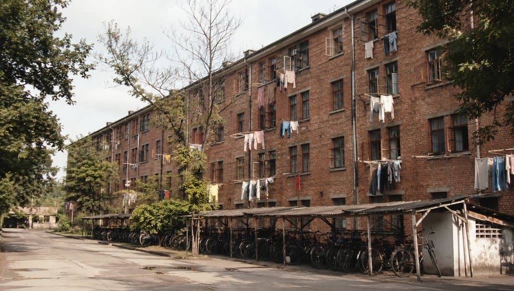 红砖工人宿舍楼，统一窗户，阳台晾晒衣物，年代感写实建筑