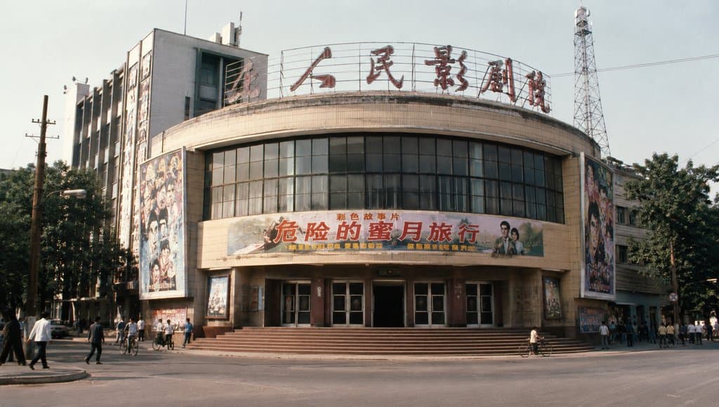 老电影院弧形立面，霓虹片名与海报墙，年代怀旧写实建筑