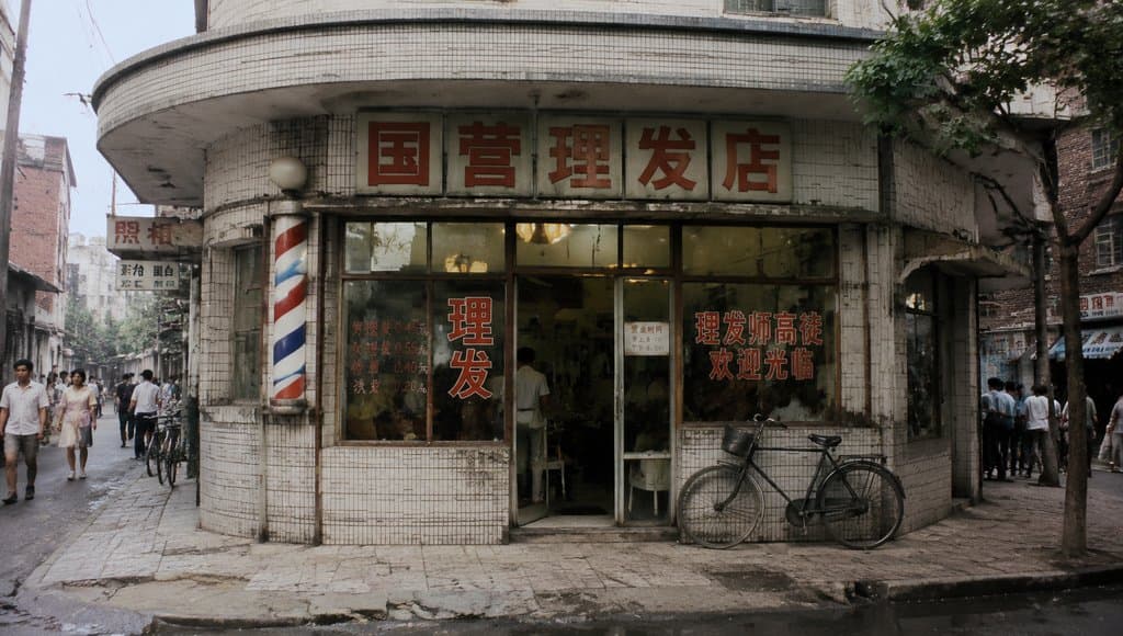 国营理发店门面，红白蓝旋转灯柱，玻璃门上贴有价格表和欢迎标语，怀旧写实风格