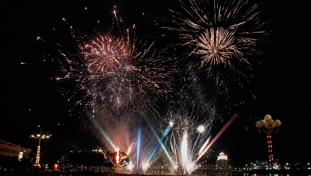 夜空中绽放的节日烟花，彩色光束与火花交织，怀旧写实风格