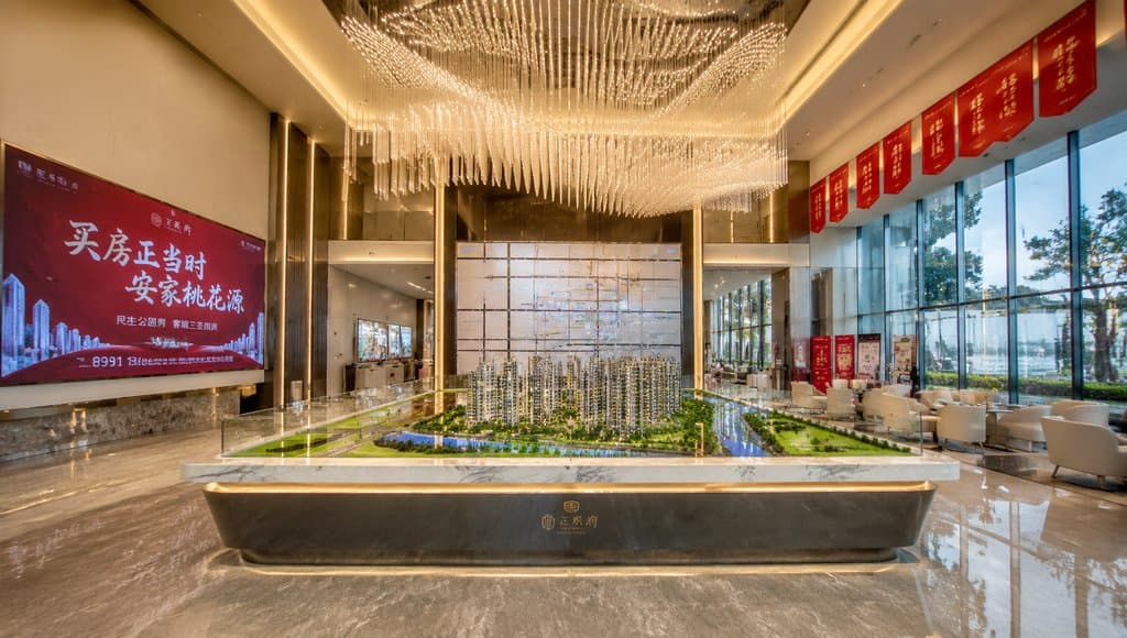 现代售楼处内部，沙盘模型展示，水晶吊灯，玻璃幕墙，洽谈区