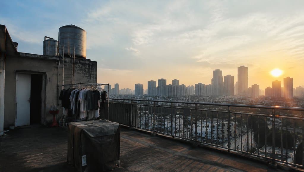 出租屋天台，水箱与晾衣架，城市远景，现代都市写实场景