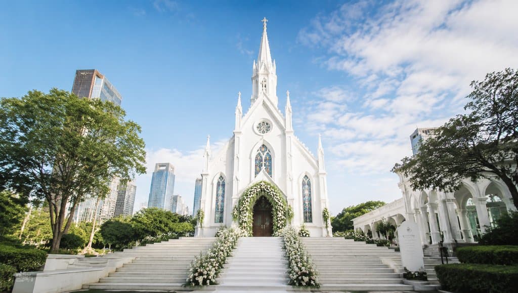 白色尖顶婚礼教堂，彩窗花艺装饰，现代都市背景