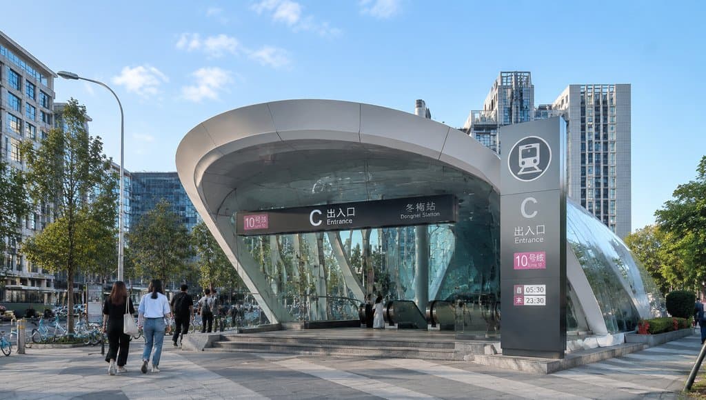 现代地铁站C出入口，流线型玻璃穹顶设计，行人穿梭，都市写实风格