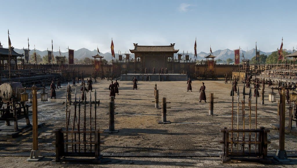 古装宫廷演武场，士兵列队训练，旌旗飘扬，兵器架与练武桩整齐排列，写实风格
