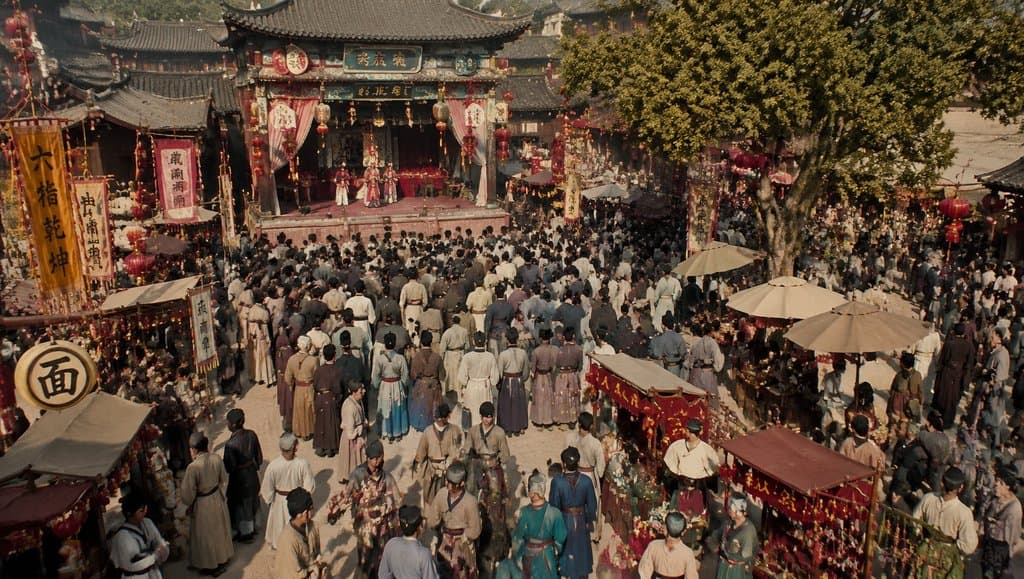 古装市集庙会场景，戏台表演与人群熙攘，灯笼高挂，写实风格
