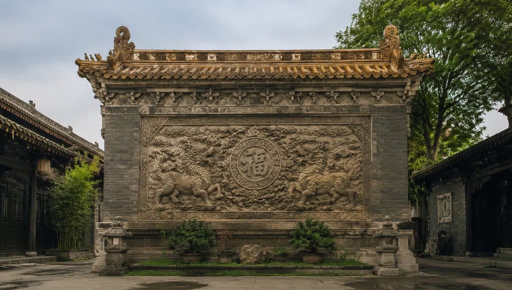 古装宫廷影壁，砖雕浮雕麒麟环绕福字，琉璃瓦顶，写实中式建筑