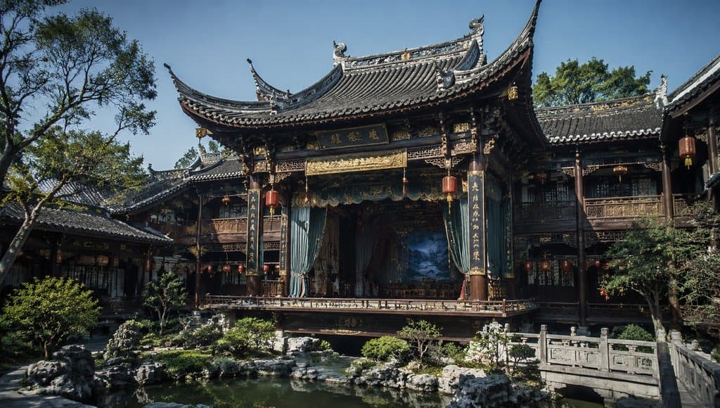 华美飞檐的世家戏楼，古装宫廷风格建筑，戏台与看台结合，雕梁画栋，红灯笼点缀，庭院水景环绕