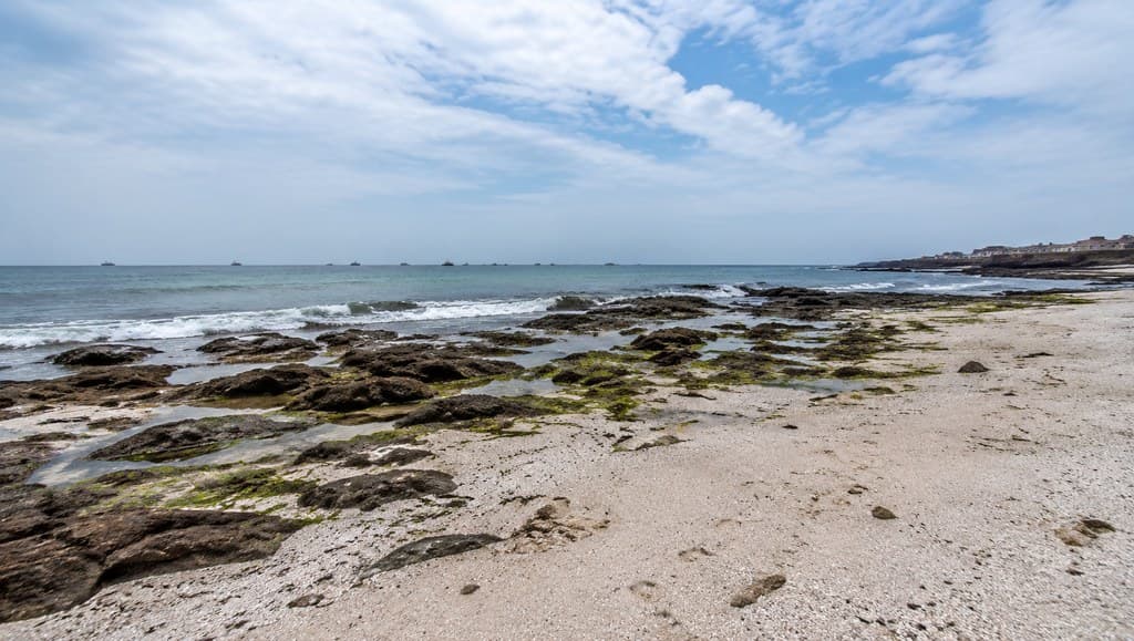 现代渔乡 海边沙滩礁石 白天 海岛写实场景图 全景