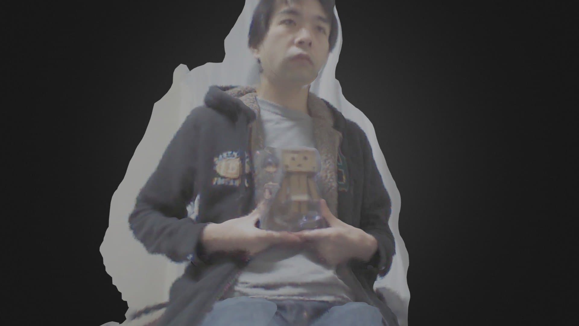 一位年轻男子手持透明人偶，身穿连帽外套，背景为黑色剪影风格