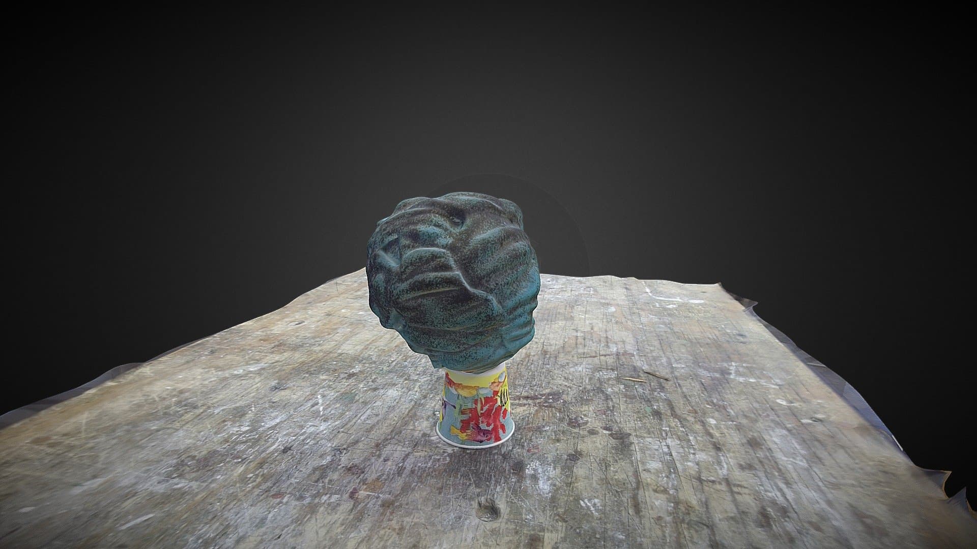 玻璃脑珊瑚3D扫描模型，蓝绿色纹理，置于彩色纸杯上，木桌背景